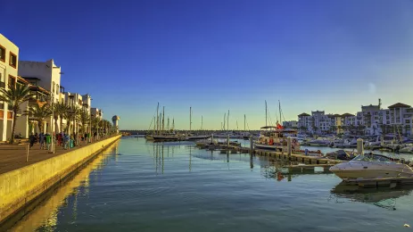 view ofthe Agadir marina full of tourists, boats and yachts at sunset