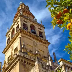 A view of the Bell Tower of Mosque-cathedral of Cordoba beneath a sky blue.