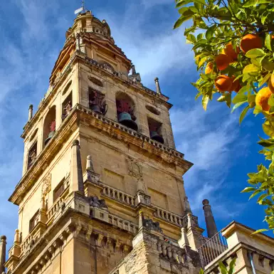 A view of the Bell Tower of Mosque-cathedral of Cordoba beneath a sky blue.