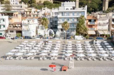 Aerial shot of a beach front with rows of loungers and parasols