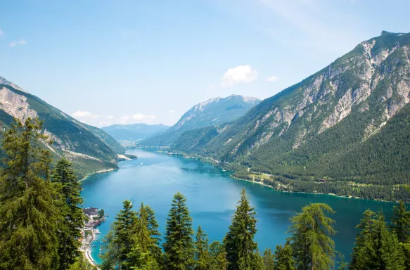 Alpine lake with fir trees and distant mountains in Tyrol, Austria
