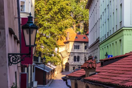 A synagogue at the end of a shaded street in a historic part of Prague